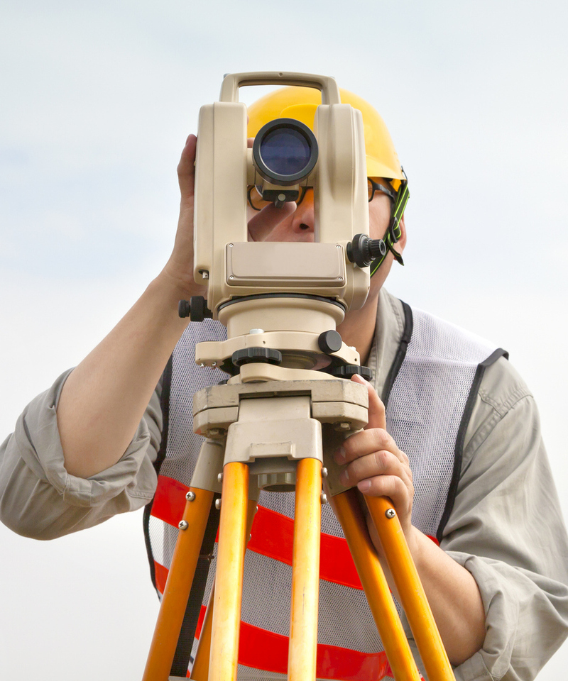 Surveyor engineer making measure with cloud background